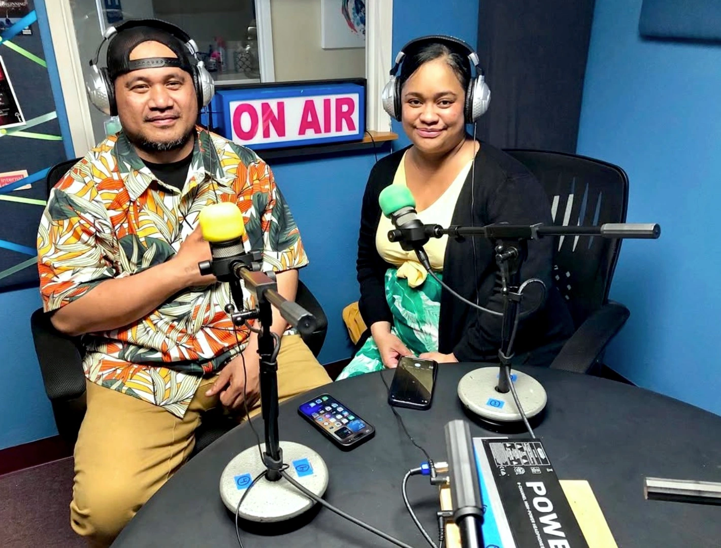 JM Otto and Dania Otto, Sakura 39ers Youth Association, at KXRW studio microphones with ON AIR sign, July 2023